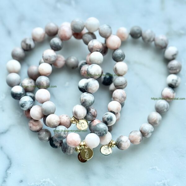 Pink and gray beaded bracelets with charms.