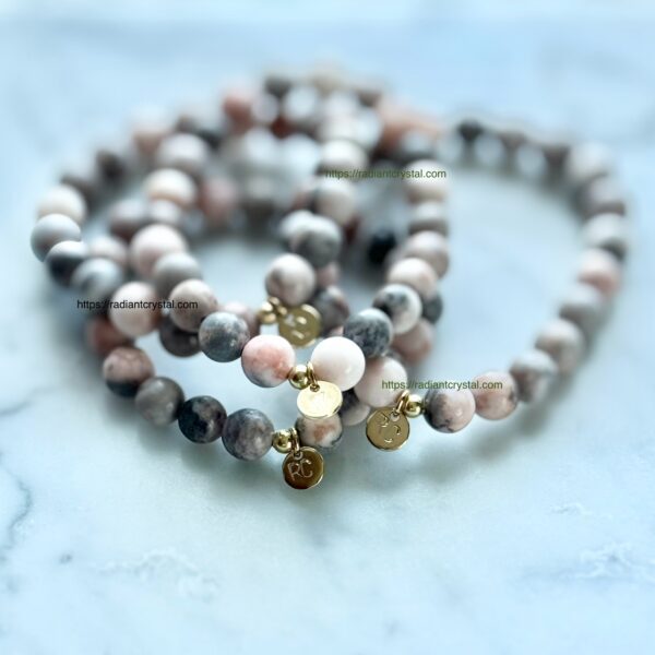 Three pink and grey beaded bracelets.