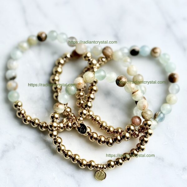 Gold beaded bracelets with green stones.