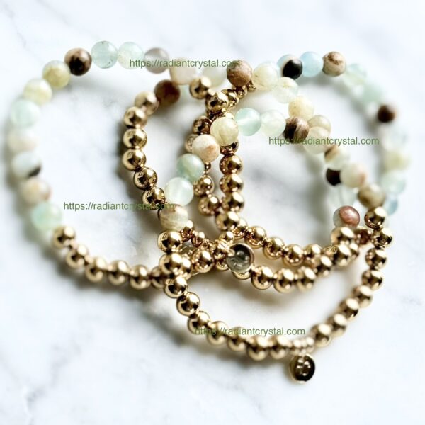 Three gold beaded bracelets with green stones.