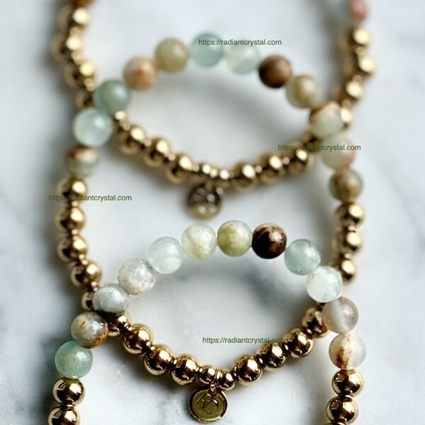 Three gold beaded bracelets with green stones.