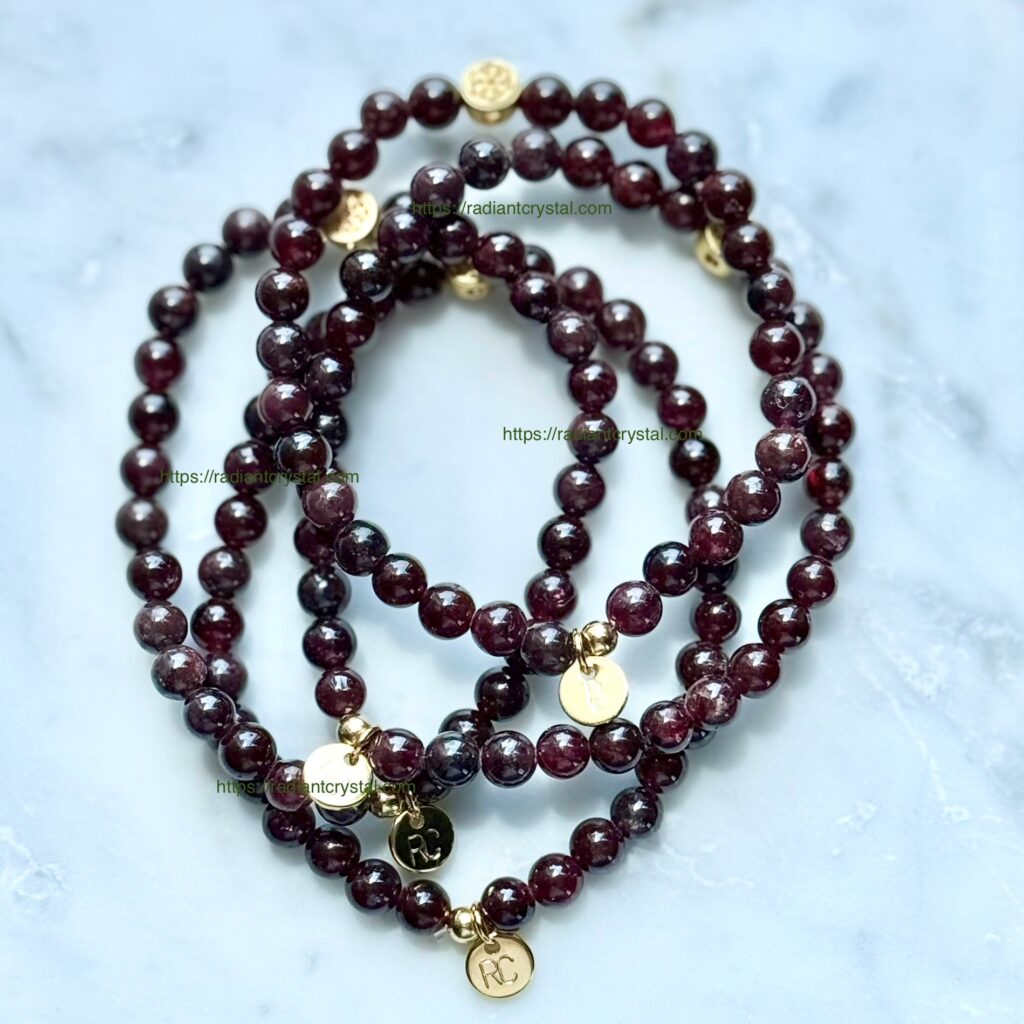 Three garnet beaded bracelets with charms.