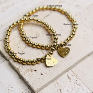 Gold beaded bracelets with heart charm.