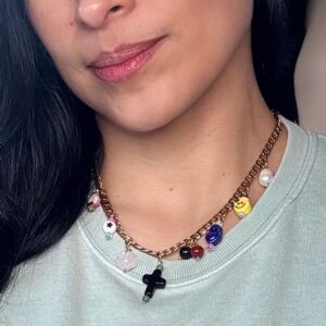Woman wearing charm necklace with cross.