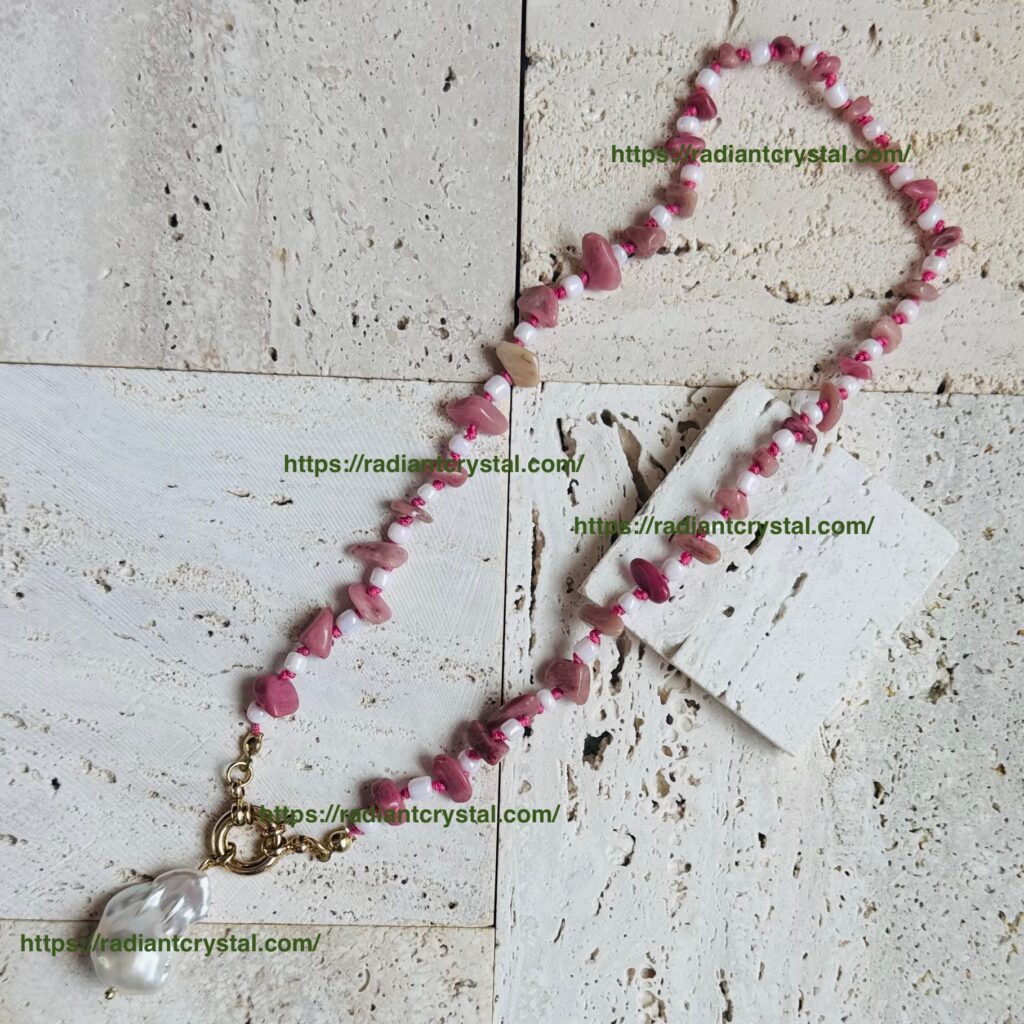 Pink bead necklace on textured surface.