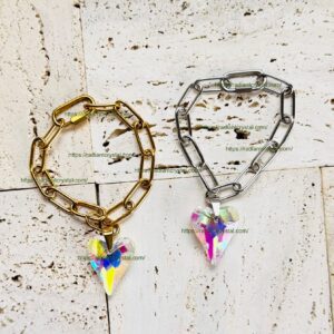 Gold and silver bracelets with heart pendants.