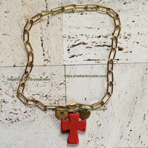 Gold chain with red cross pendant.