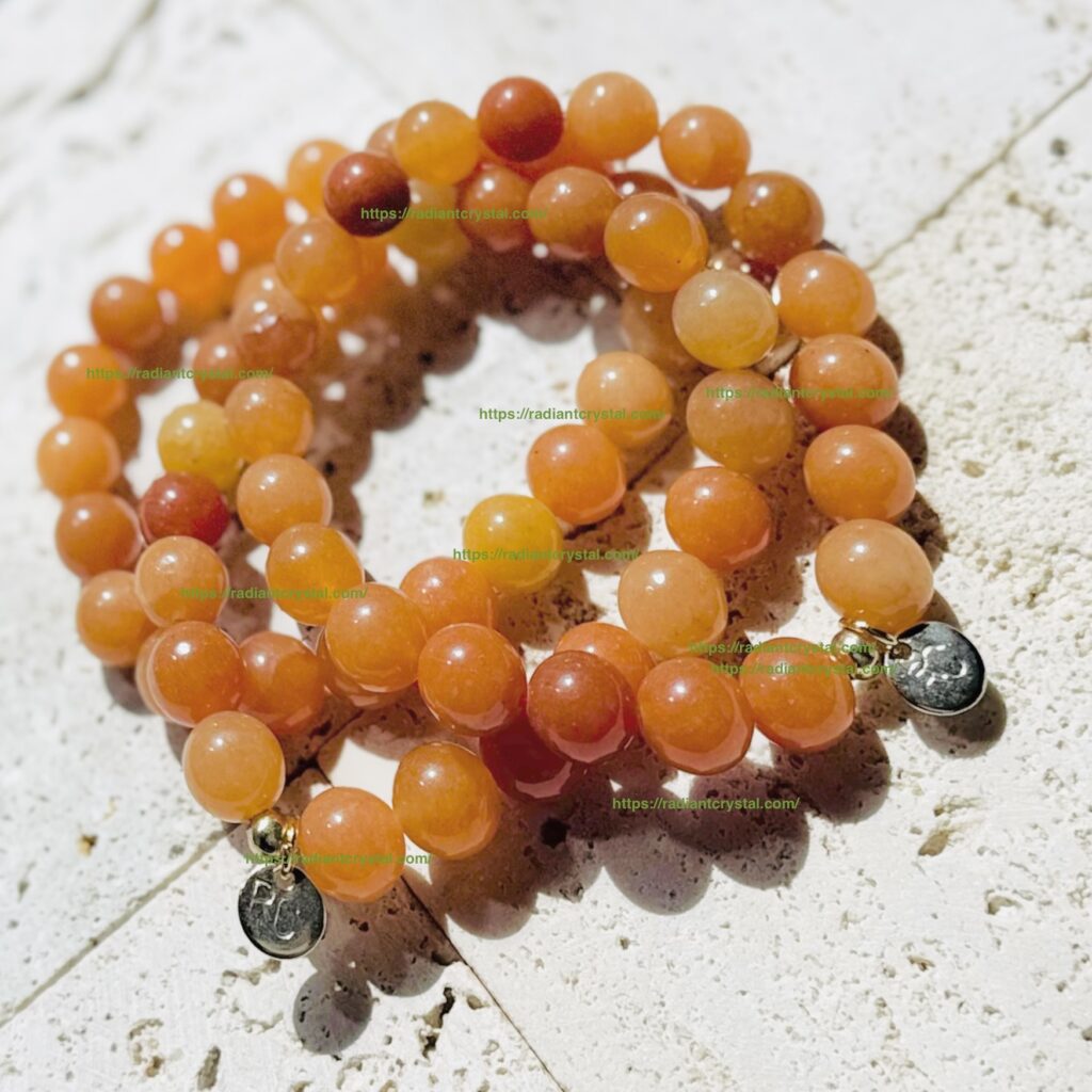 Orange gemstone bracelets with silver charms.
