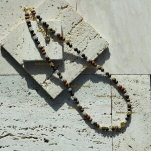 Beaded necklace on textured stone surface.